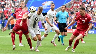 Milos Veljkovic schaut im Spiel gegen Slowenien fokussiert auf den Ball während eines Angriffs der Slowenen.