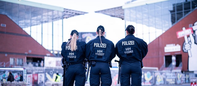 Drei Polizistinnen stehen vor dem Millerntorstadion in Hamburg.