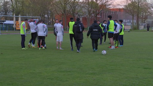 Zu sehen sind mehrere Fussballer auf einem Trainingsplatz.