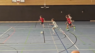 Ein junger Werder-Spieler der U14 läuft mit dem Ball am Fuß durch eine Halle auf das Tor zu.