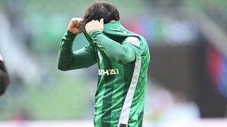 Werder-Spieler Leonardo Bittencourt zieht sich nach der Niederlage gegen Gladbach frustriert das Trikot über den Kopf.