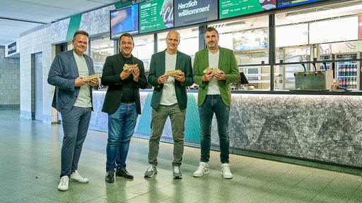 Thomas Gutzeit, Pascal Lagardère, Klaus Filbry und Hans-Jörg Otto vor einem der neu gestalteten Kioske im Umlauf bei der Vorstellung des neuen Gastrokonzeptes von Werder und Supreme Sports Hospitality.