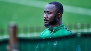 Werder-Spieler Naby Keita schaut nachdenklich am Rande des Trainings.