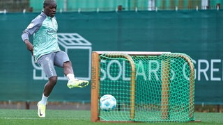 Werder-Spieler Derrick Köhn schießt den Ball im Training in ein kleines Tor.