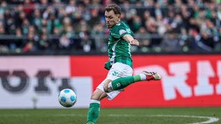 Werder Senne Lynen holt zum Schießen aus. Vor ihm befindet sich der Ball.