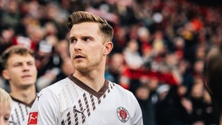 Fußball-Profi Johannes Eggestein schaut nachdenklich beim Einmarsch ins Stadion des FC St. Pauli.