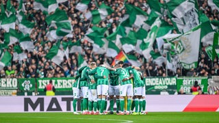 Werders Fußballer stehen im Weser-Stadion und bilden einen Kreis.