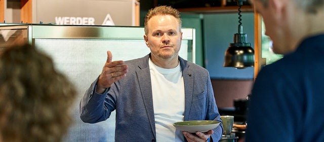 Thomas Gutzeit, zuständig für das Catering im Weserstadion, hält einen Teller in der Hand.