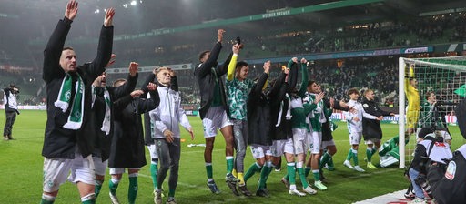 Die Werder-Spieler hüpfen aufgereiht nebeneinander vor der Ostkurve im Weser-Stadion und bejubeln ihren Sieg gegen Union Berlin.