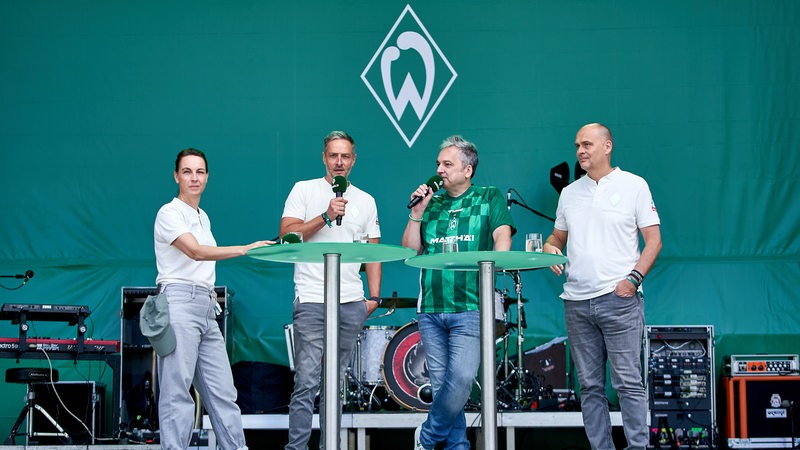 Werders Anne-Kathrin Laufmann, Tarek Brauer, Arnd Zeigler und Klaus Filbry stehen am Tach der Fans auf der Bühne.