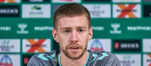 Mitchell Weiser sitzt bei einer Pressekonferenz des SV Werder Bremen.