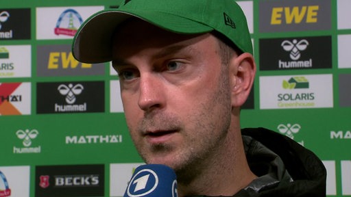 Werder-Trainer Ole Werner steht vor einer Werbewand bei einem Interview nach der Niederlage gegen Freiburg.