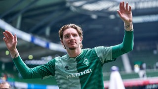 Werder-Stürmer Nick Woltemade bedankt sich mit weit ausgebreiteten Armen bei den Fans im Weser-Stadion.