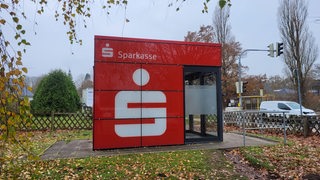 Blick auf ein rotes Gebäude mit der Aufschrift "Sparkasse"