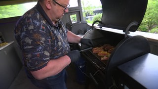 Michael Leefers legt Lachsfilets auf den Grill