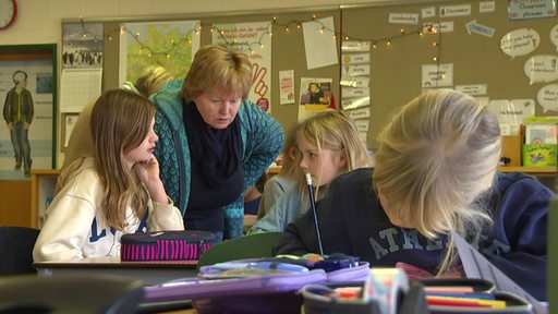 Eine Klassenlehrerin mit Grundschulkindern beim lernen