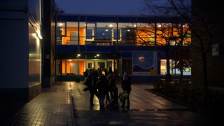 Kinder stehen am Morgen vor der Tami-Oelfken-Grundschule in Bremen-Lüssum.