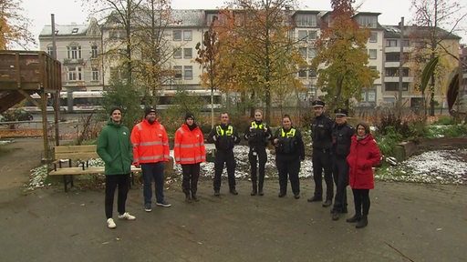 Eine Gruppe aus Zivilisten und Polizisten 