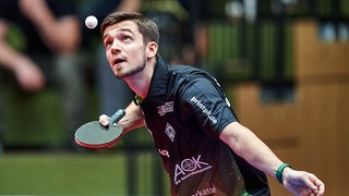 Werders Tischtennis-Spieler Kirill Gerassimenko konzentriert sich beim Aufschlag auf den Ball in der Luft.