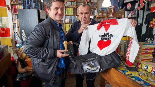 Marco Heuberg und Andree Höttges präsentieren ein Trikot von Horst-Dieter Höttges.