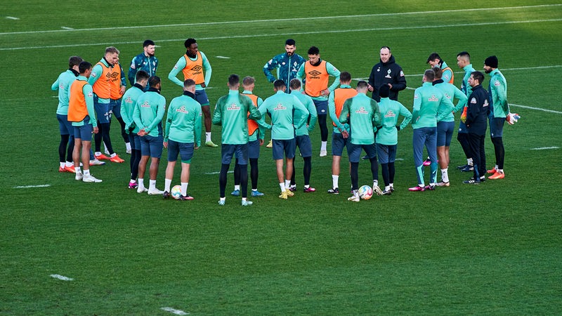 Die Werder-Spieler umringen während des Trainings Coach Ole Werner, der ihnen etwas erklärt.