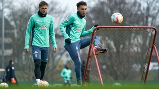 Die Werder-Spieler Niklas Stark und Lee Buchanan spielen beim Training hohe Pässe.