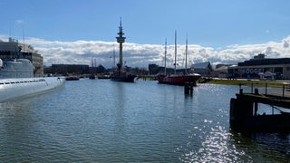 In einem Hafenbecken liegen Schiffe und ein U-Boot.