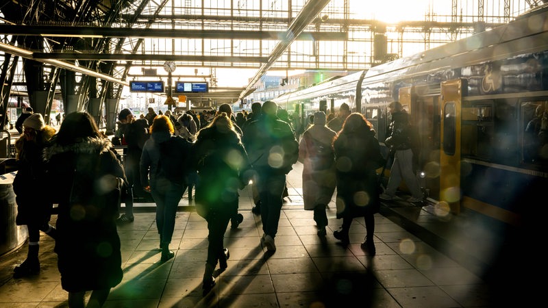 Reisende stehen an einem Gleis vom Bremer Hauptbahnhof. 