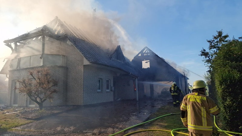 Feuerwehrleute löschen ein brennendes Haus