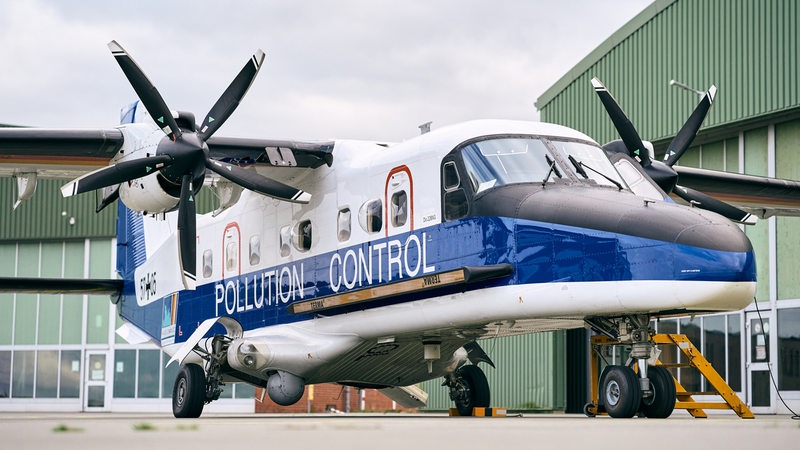 Ein Spezialflugzeug steht vor einem Hangar.