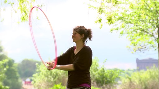 Eine Frau mit einem Hoola-hoop-Reifen im Park