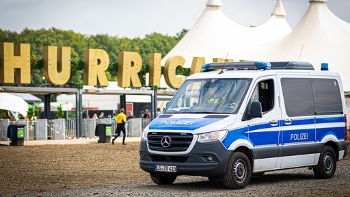 Ein Einsatzfahrzeug der Polizei fährt vor dem Gelände des Hurricane Festivals entlang. 