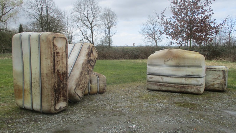 Mehrere große Tanks liegen auf einer Wiese.