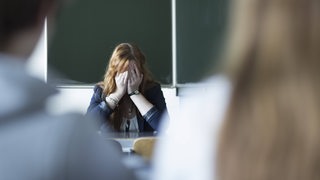 Verzweifelte Lehrerin im Klassenzimmer,