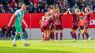 Enttäuschte Werder-Fußballerinnen, während die Bayern-Spielerinnen ihr Tor bejubeln.