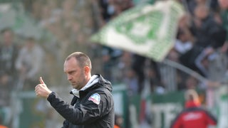 Werder-Trainer Ole Werner reckt den Daumen in die Höhe.