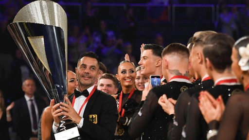 Roberto Albanese, Trainer vom Grün-Gold-Club Bremen, hält den WM-Pokal in die Höhe