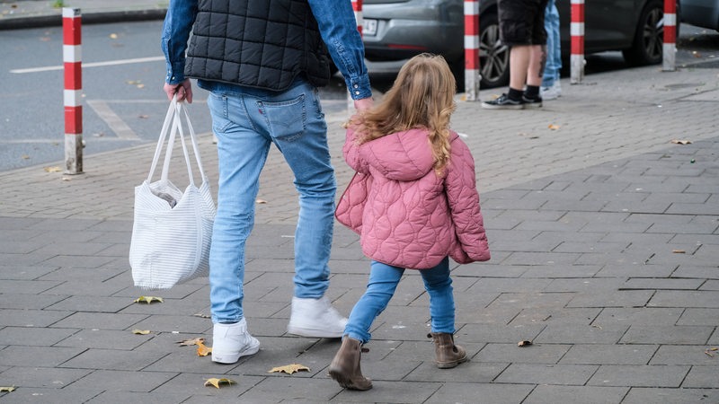 Mann mit Mädchen an der Hand