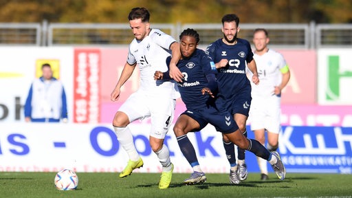 Spieler von Waldhof Mannheim und dem VfB Oldenburg kämpfen um den Ball.