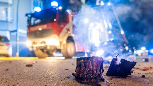 Ein Fahrzeug der Feuerwehr steht hinter einem ausgebrannten Feuerwerk.