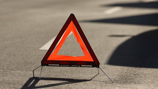 Ein Warndreieck steht auf einer Straße