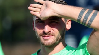 Maximilian Philipp schaut konzentriert und hält die Hand vor die Stirn.