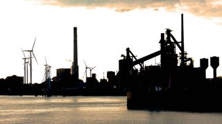 Blick auf ein Industriegelände bei untergehender Sonne.