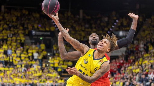 Der Oldenburger Basketballer DeWayne Russell und Bayern Othello Hunter kämpfen im Top-Four-Finale um den Ball.