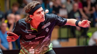 Werders Tischtennis-Spieler Cristian Pletea fokussiert beim Aufschlag den hochgeworfenen Ball.