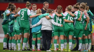 Werder-Trainer Thomas Horsch umringt von seinen Fußballerinnen nach dem Spiel.