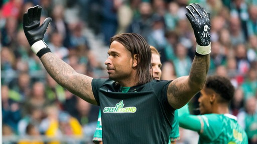 Ex-Werder-Torhüter Tim Wiese hebt die Hände und dreht sich zur Ostkruve.