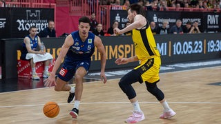 Basketballer Jarelle Alexander Reischel von den Eisbären Bremerhaven im Zweikampf mit einem Tübinger Spieler.