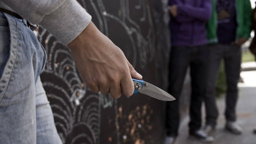 Teenager mit Klappmesser in der Hand.