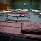 Turnhalle mit Feldbetten für Geflüchtete